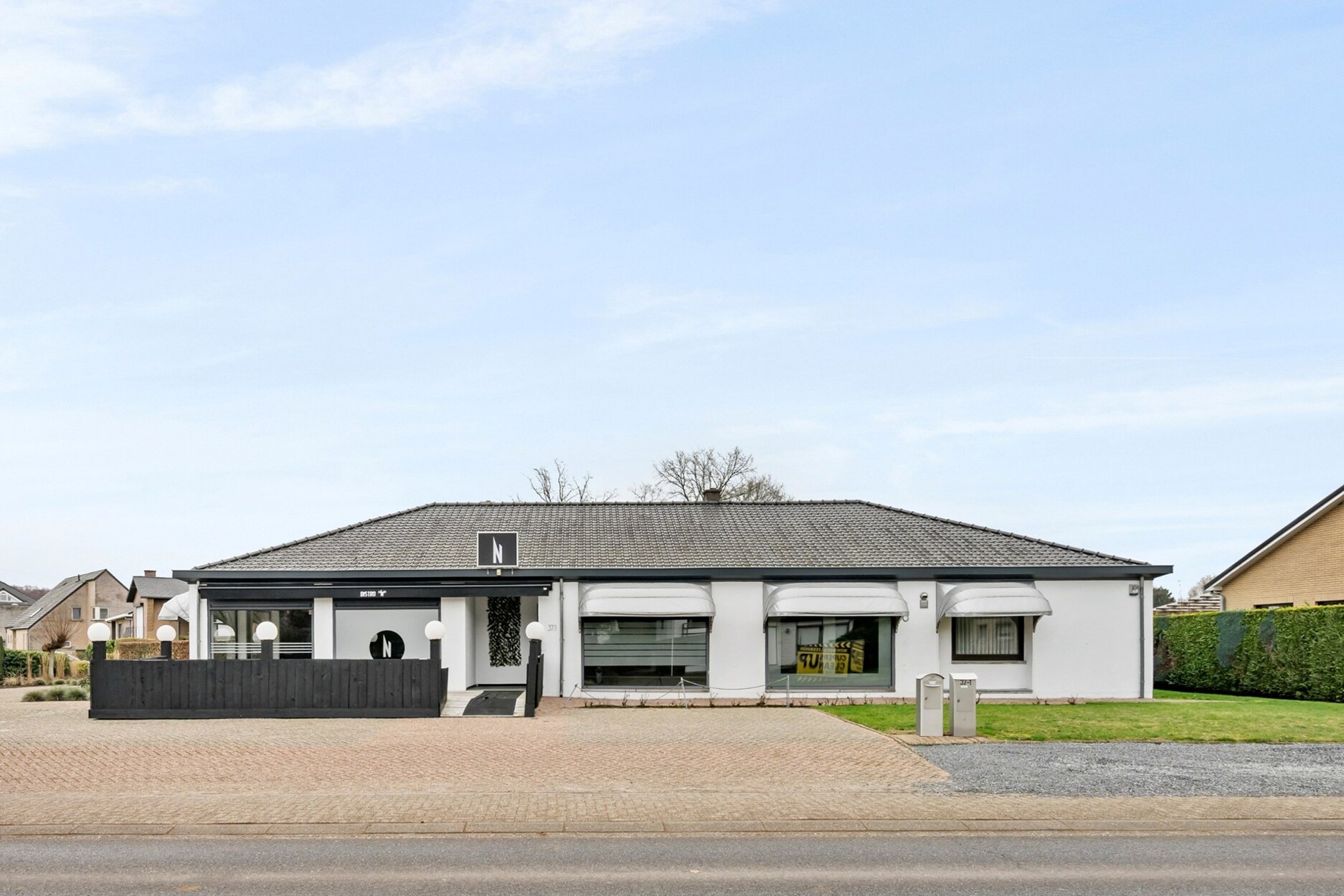 Opbrengsteigendom (handelsruimtes en 1 gelijkvloerse woonst), op een goede zichtlocatie te Heusden-Zolder!